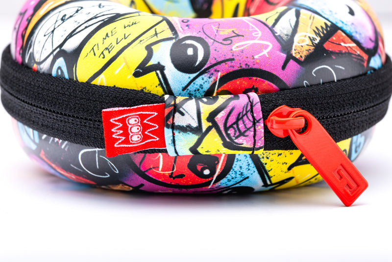 Colorful graffiti-patterned case with a red zipper on a white background